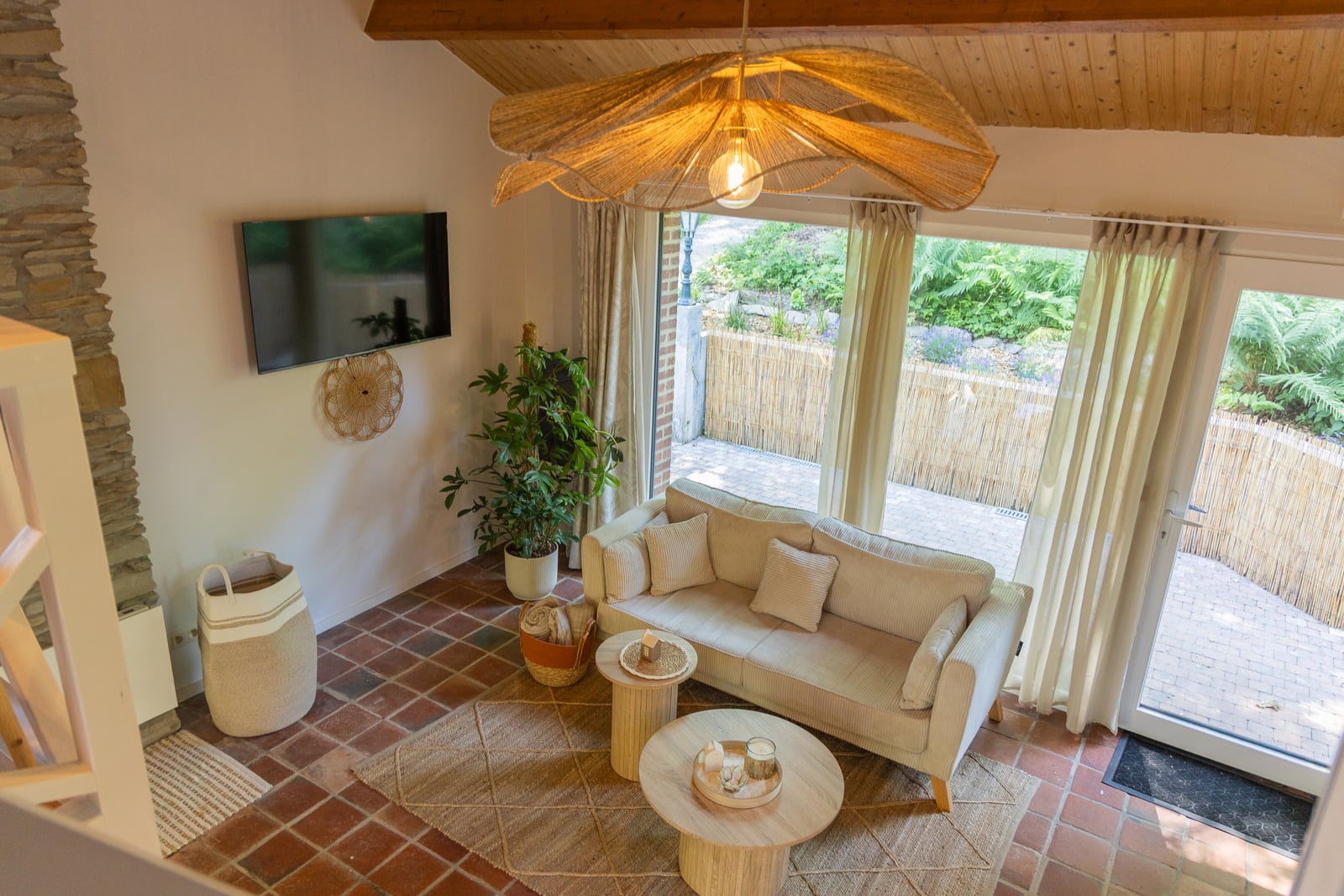 View from above of the living room and its large natural-fibre pendant light