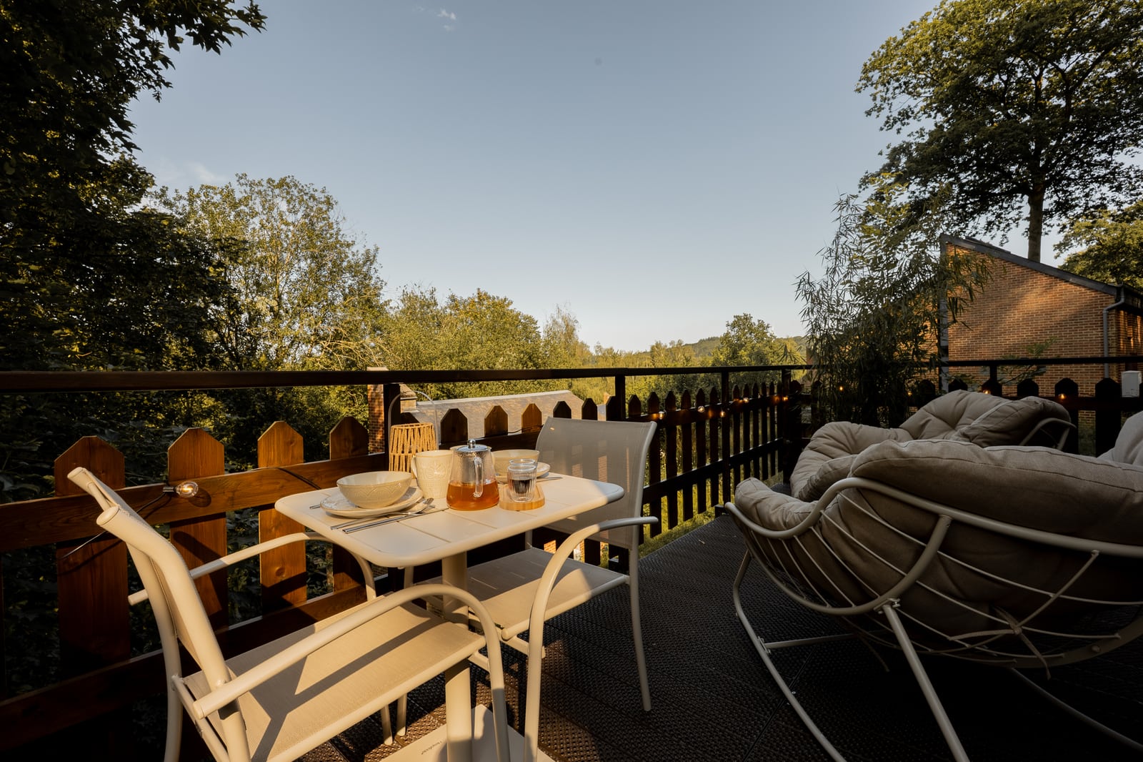 Furnished terrace with a table for two, armchairs and a valley view